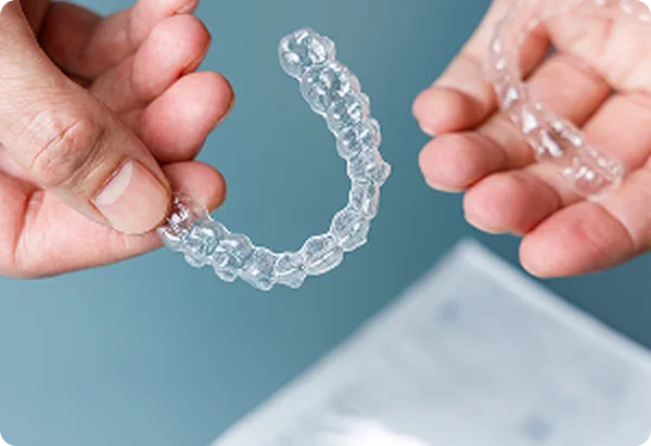 Gouttière orthodontique transparente tenue à la main